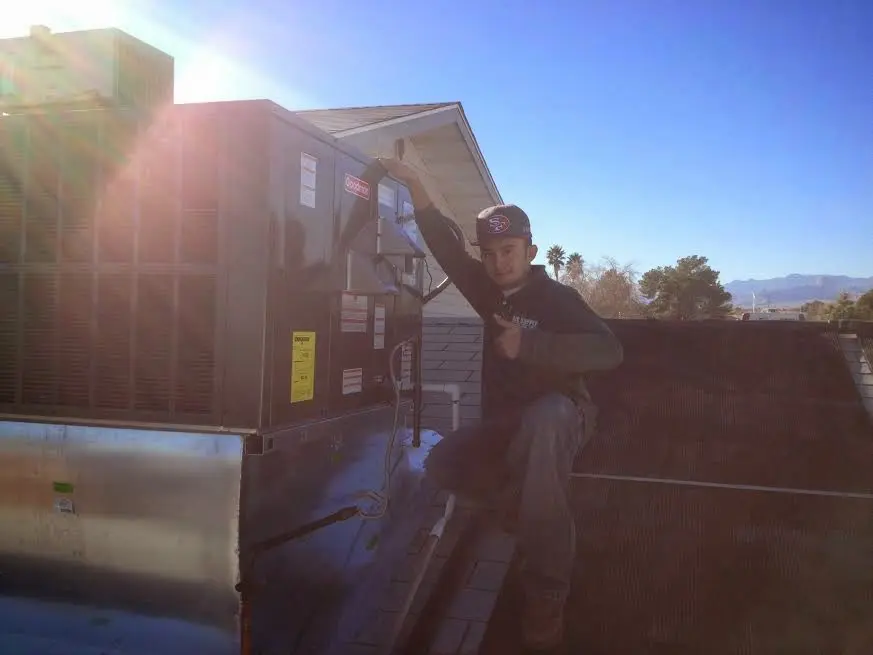 HVAC technician performing Boiler Repair on a rooftop unit in Rialto
